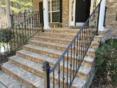 Angled view of black decorative balusters on broad front entrance steps