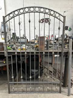 Arched pedestrian gate with circular and floral ornaments in the workshop