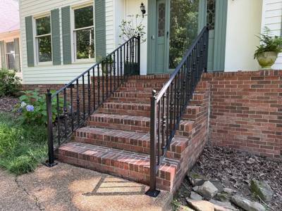 Black decorative balusters and handrails on brick front steps