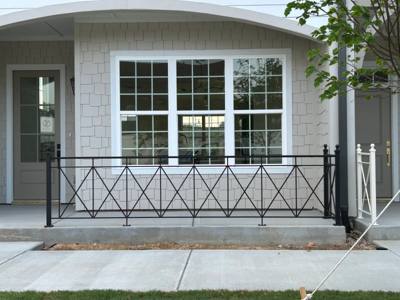 Black diamond-pattern railing across a covered porch