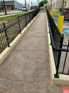 Black fencing lining both sides of an outdoor access ramp