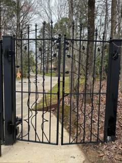 Black garden gate with spear tops and an inset diamond pattern