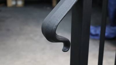 Black handrail end with a short outward curl