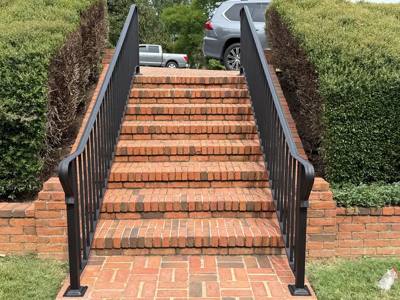 Black handrails framing a long flight of landscaped brick steps