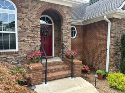 Black handrails framing brick steps at an arched front entrance