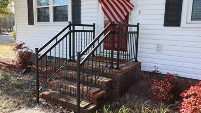 Black handrails on brick steps beneath an American flag