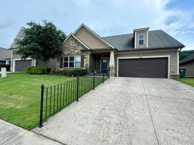 Black picket railing following a curved driveway beside a front lawn