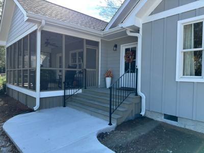 Black porch and stair railings at a blue-sided screened entrance