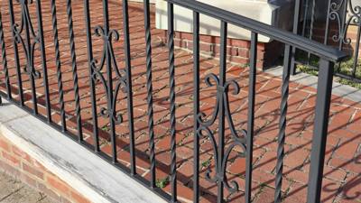 Black porch railing with twisted pickets and scrollwork accents