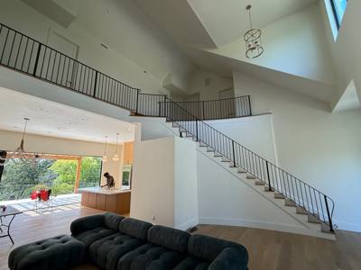 Black railing along an interior staircase and open upper floor