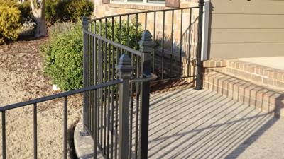 Black railing corner casting shadows across a concrete landing