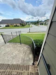 Black railing following a curved driveway wall viewed from above