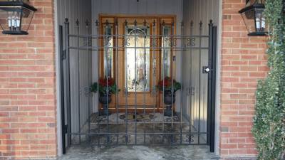 Black railing panels around a small stone entry landing