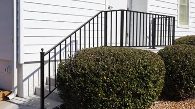 Black railings around brick steps and a raised side landing