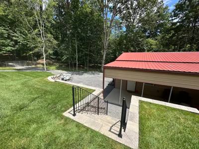 Black railings around concrete steps leading down to a lawn