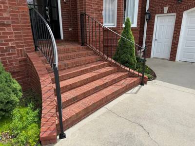 Black railings flanking broad curved brick entrance steps