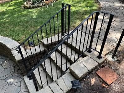 Black railings flanking stone landscape steps viewed from above