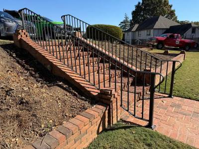 Black railings following a long flight of landscaped brick steps