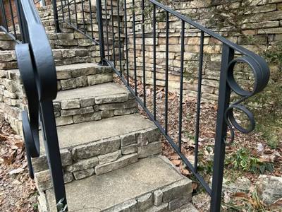 Black railings with circular end ornaments following stone garden steps