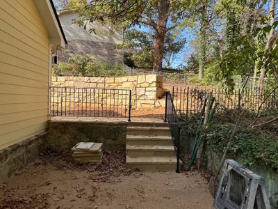 Black rails around an elevated patio and short concrete stairway