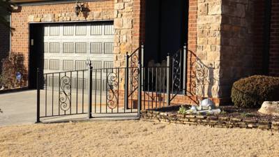 Black scroll-accent railing bordering a small stone-faced entrance terrace