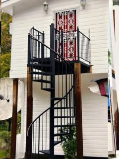 Black spiral staircase serving an elevated exterior doorway