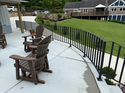Black vertical-bar railing around a curved concrete patio edge