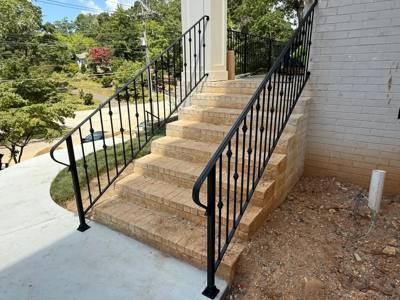 Black vertical-bar railings on a long outdoor concrete stairway