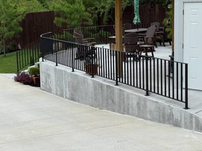 Black vertical-picket railing along a raised covered patio