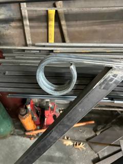 Circular metal scroll components resting on a workshop workbench