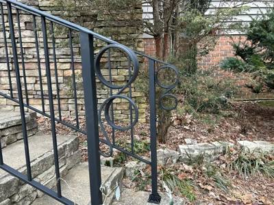 Circular ornaments decorating the end of a black garden stair railing