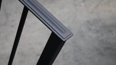 Close-up of a shaped top rail meeting a square black post