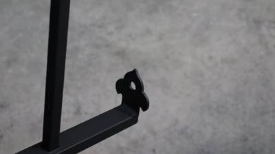 Close view of a flower-shaped wall bracket on a black handrail