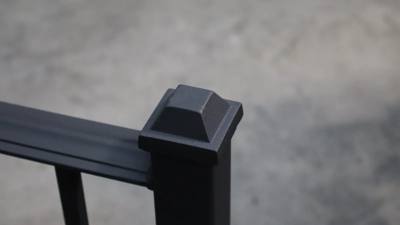 Close view of a pyramid cap on a square black railing post