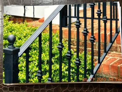 Close view of black railing pickets with decorative collars and ball-topped posts