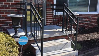 Close view of black stoop railings beside a decorative urn