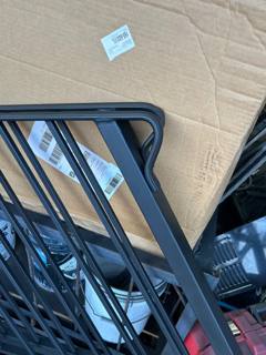 Close view of dark railing panels with rounded corners stacked in a workshop