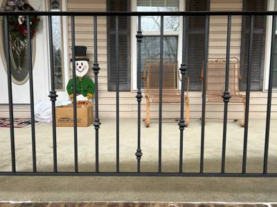 Close view of decorative balusters in a black porch railing