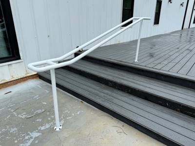 Close view of white handrail returns beside gray decking