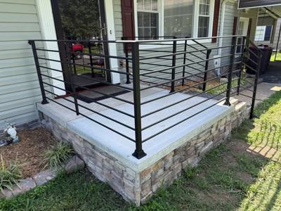 Corner view of horizontal black deck railing beside a white-sided house