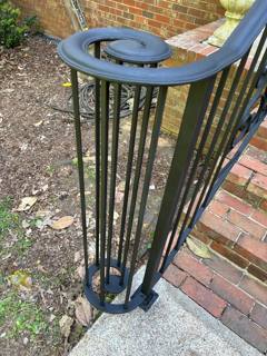 Curled top rail end above slender vertical railing pickets