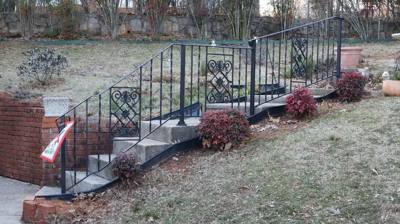 Decorative black railing along a winding entrance path and steps