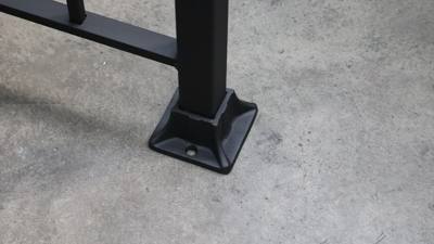 Decorative flared base around a square black railing post