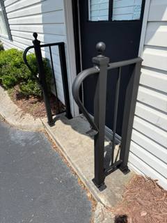 Decorative looped handrail beside a small dark entrance door