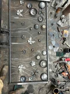 Decorative metal flowers and circular components arranged on a workshop table