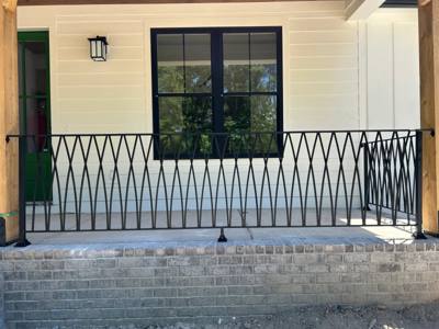 Diamond-pattern black railing across a covered porch