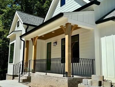 Diamond-pattern railing across a timber-post porch with pale siding