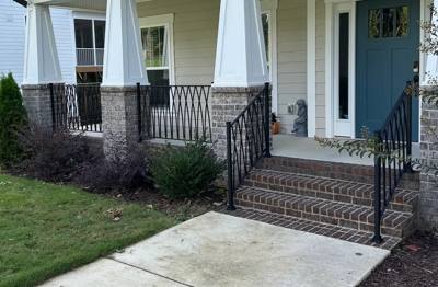 Diamond-pattern railings surrounding a front porch and brick entrance steps