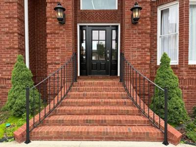 Front view of brick entrance steps with slender black railings