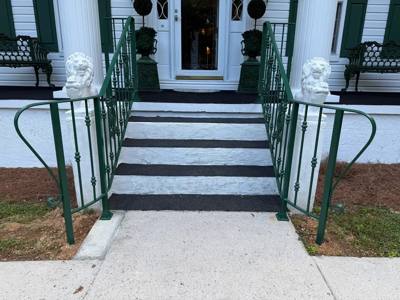 Green handrails flanking contrasting dark-and-light front steps